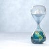 Hourglass with Earth inside with an glacier melting above - global warming concept