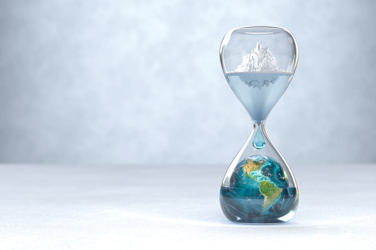 Hourglass with Earth inside with an glacier melting above - global warming concept