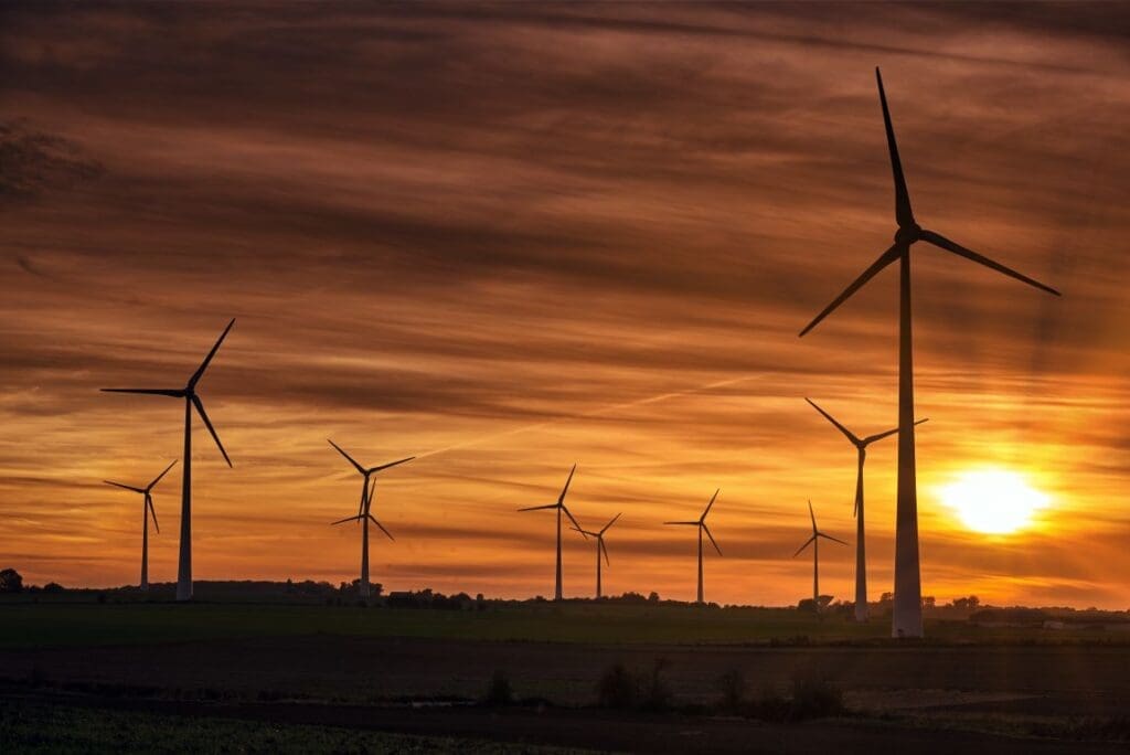 Image: Silhouette of windmills on a field during sunset (s. climate, finance)