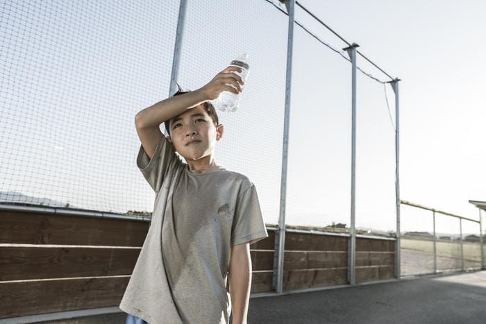 Extreme heat associated with children’s asthma hospital visits A boy tired out after practice wipes his sweaty head (s. asthma, extreme heat, climate)