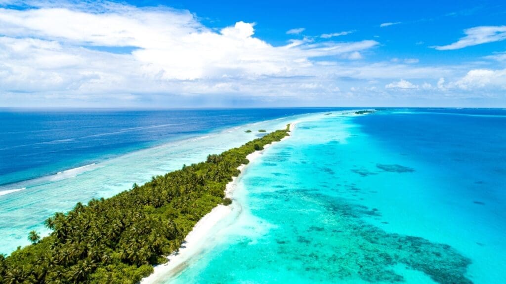 Low-lying Maldives seeks easier funding to battle waves aerial shot narrow island covered by tropical trees middle sea maldives res