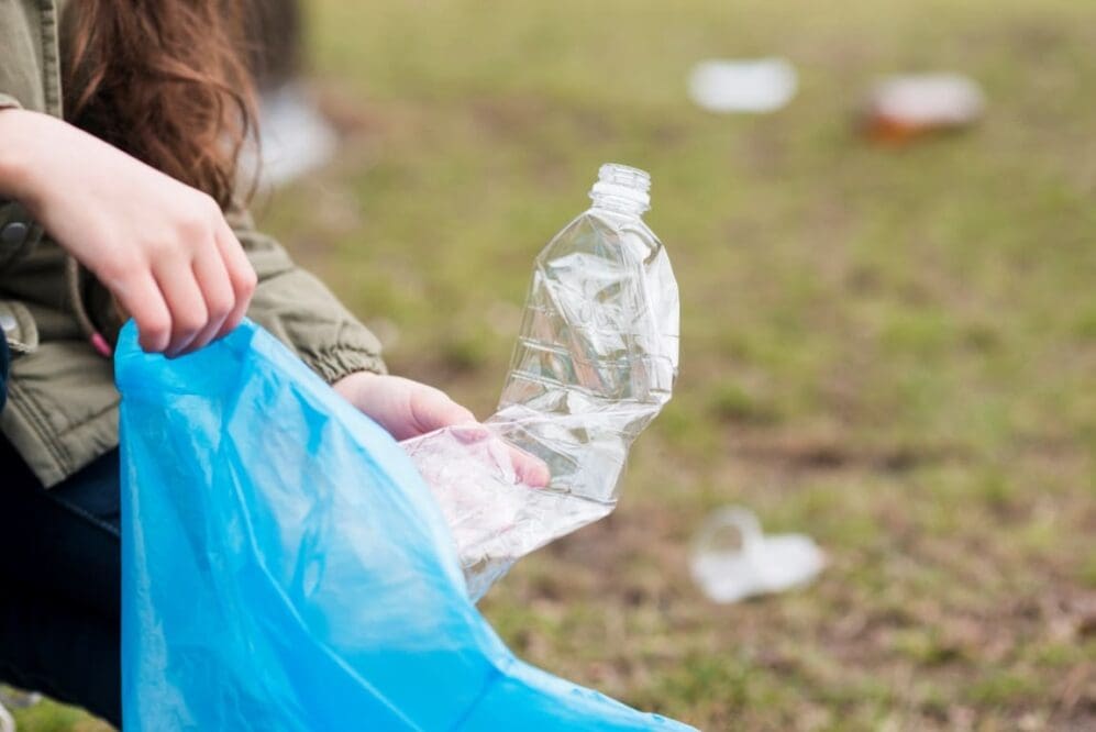 Image: Girl cleaning the plastic bottle from ground