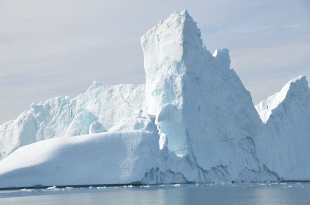 Image: Shiny glacier near sea under cloudy sky