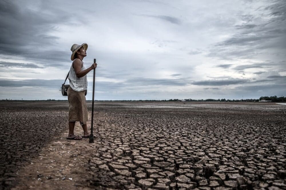 Image: Women standing on dry soil and fishing gear, global warming and water crisis