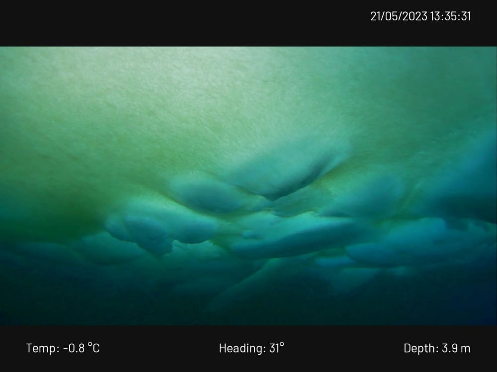 Some coloration of the ice algae growth at the bottom of the ice, which appears green here, as well as some deformation/ridging of the ice