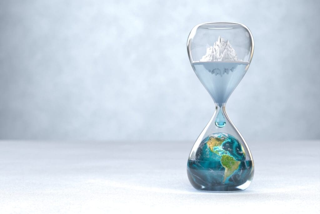 Hourglass with Earth inside with an glacier melting above - global warming concept (s. climate anxiety, climate overshoot)