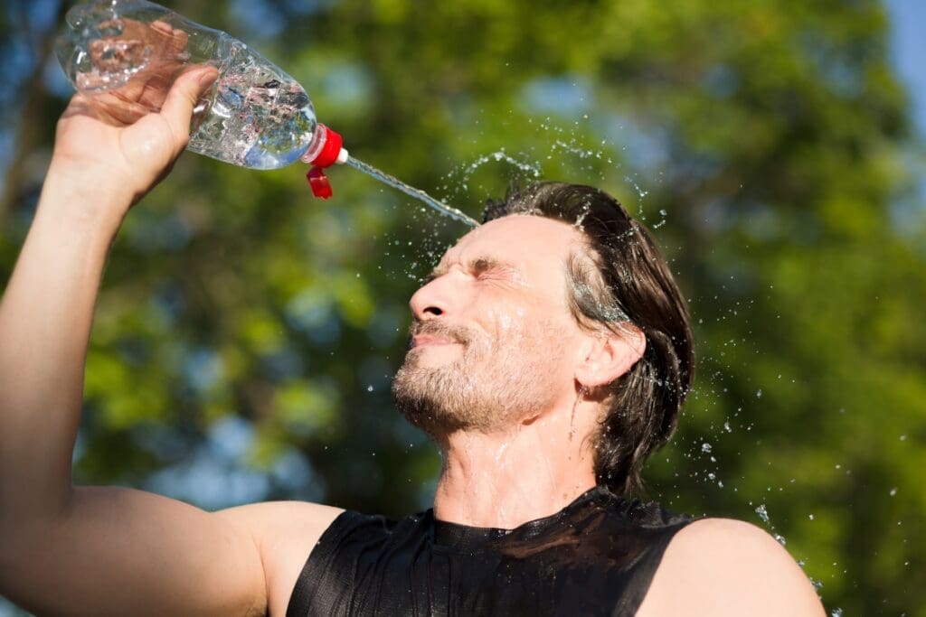 Image: Fitness runner drinking and splashing water in his face