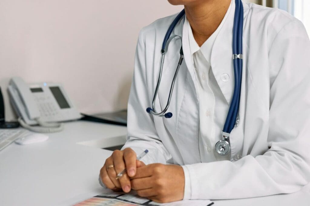 A Woman (doctor) in White Coat Sitting at the table (health care, climate)