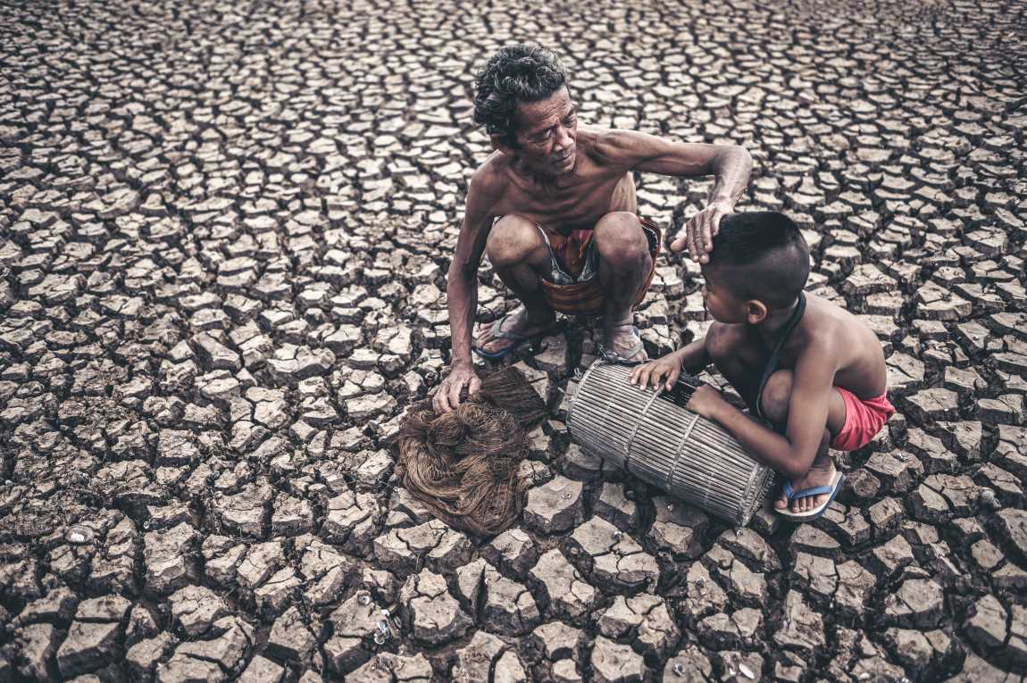 Image: Elderly men and boy find fish on dry ground, global warming