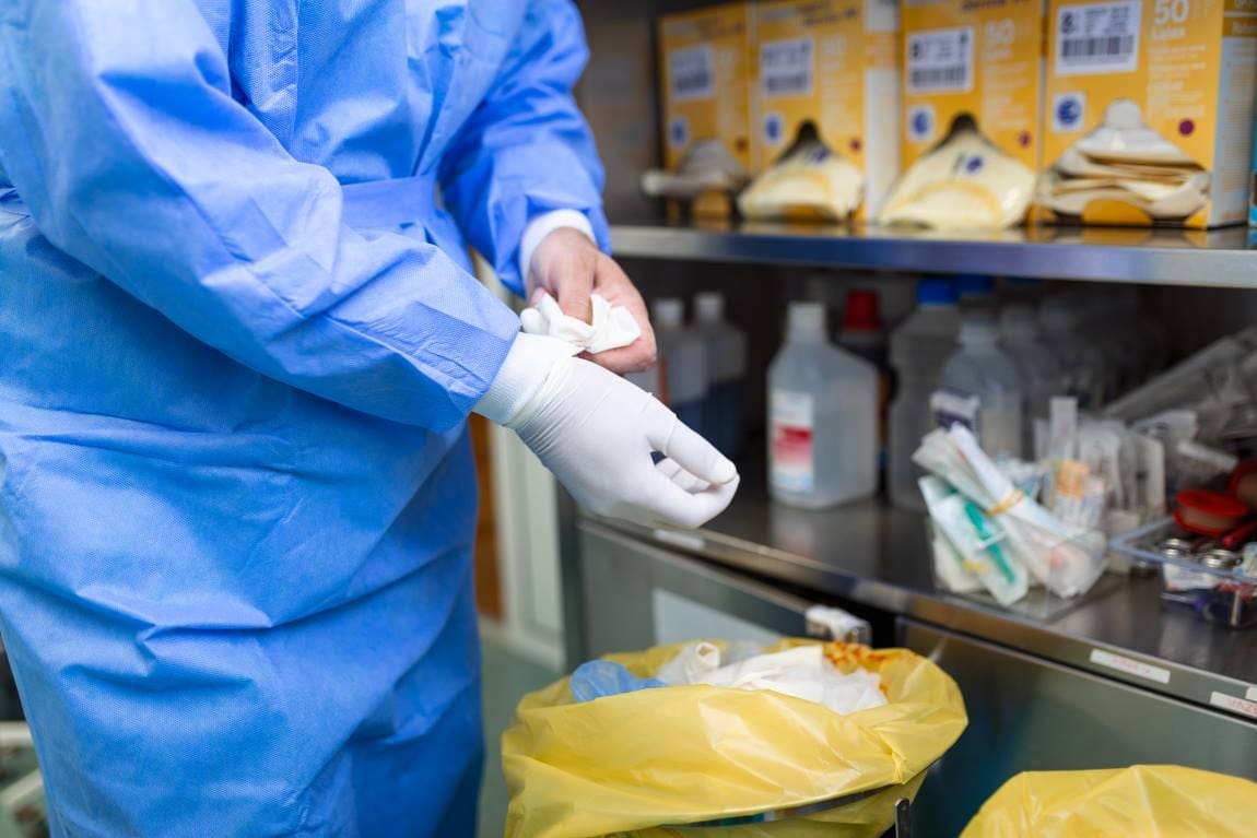 Image: Male surgeon removing surgical gloves in operation theater at hospital