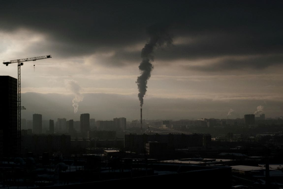 Image: Smoke coming out of a tall smokestack in a city