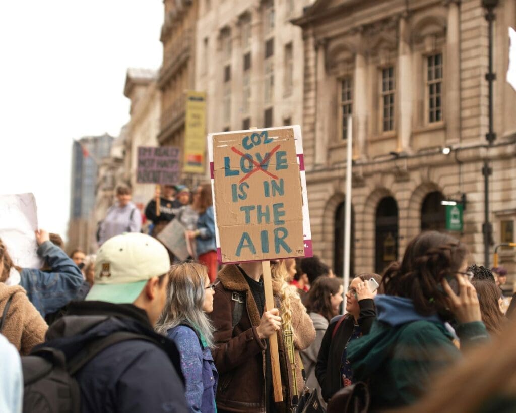 What we can do about Gen Z's climate anxiety Image: person holding co2 love is in the air signage
