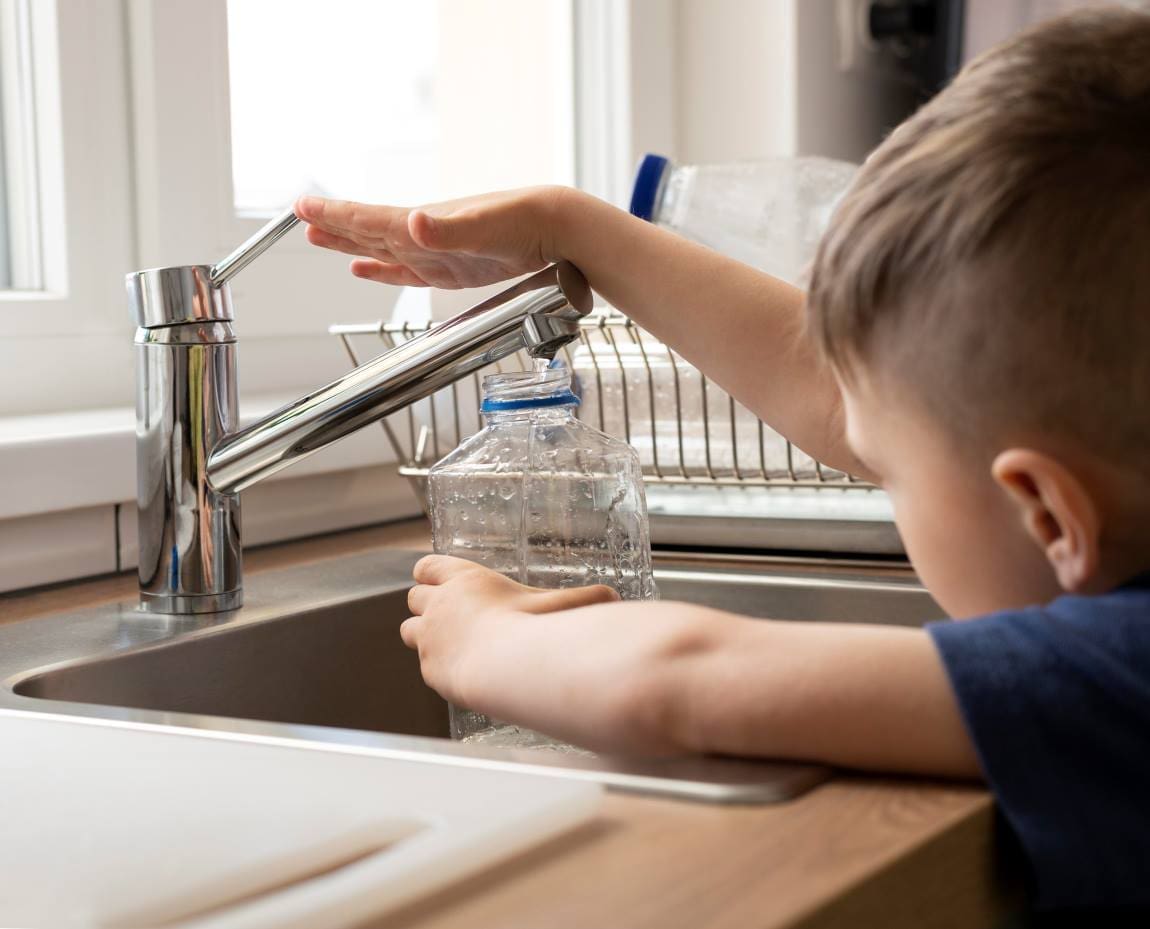 Image: Close up kid filling bottle with water