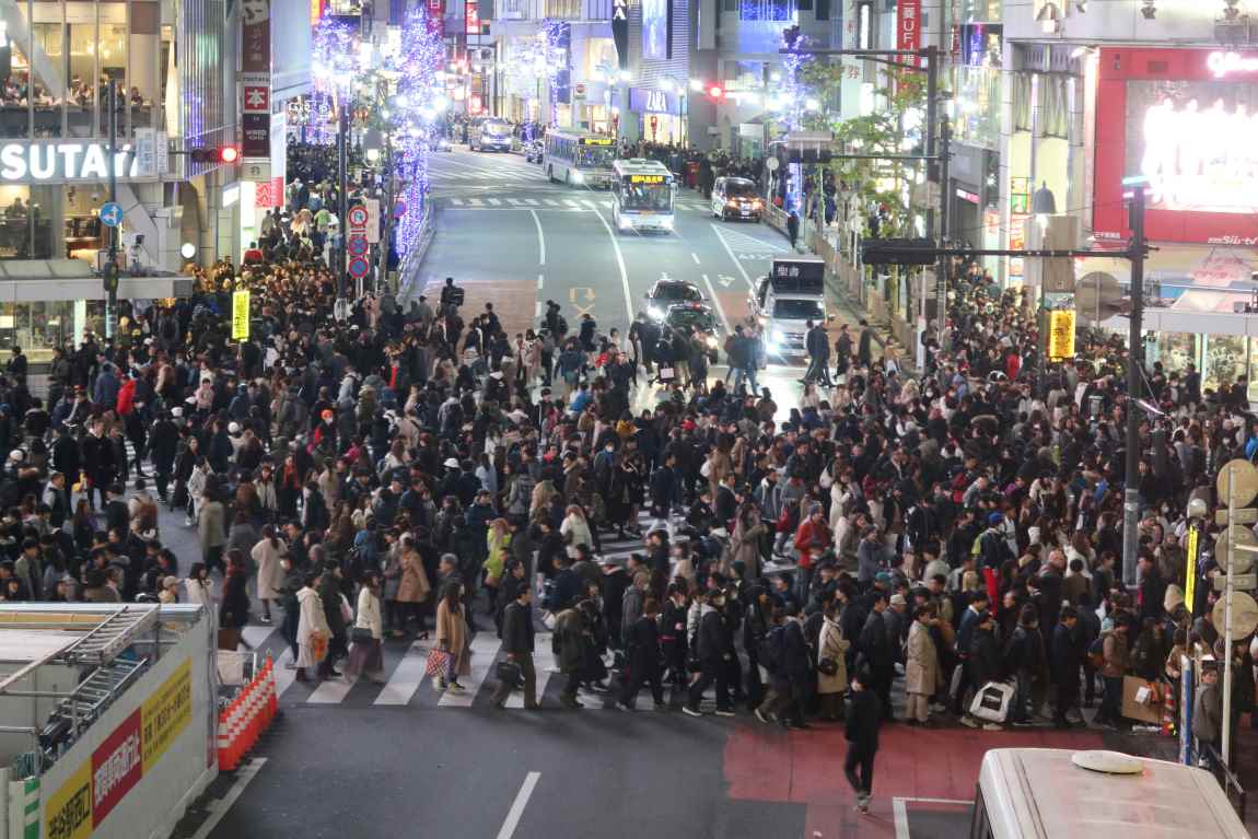 Large group of people walking across a street (s climate, environment, taxes)