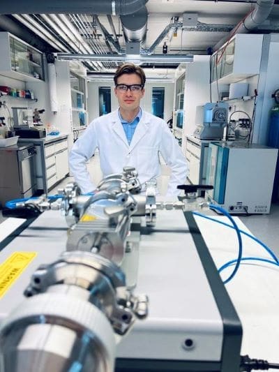 Cedric David Koolen, co-lead author of the study, posing with the spark ablation device used to generate the clusters in the Laboratory of Materials for Renewable Energy