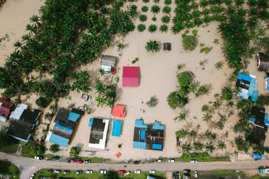Climate change trauma and collective dissociation Aerial view of village after flood (s. climate change, climate trauma)