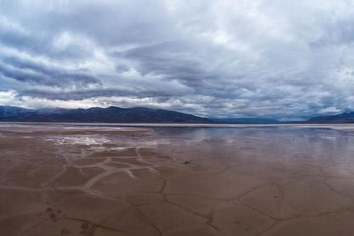 Cracked mud and salt on the valley floor in Death Valley National Park in California can become a reflective pool after rains