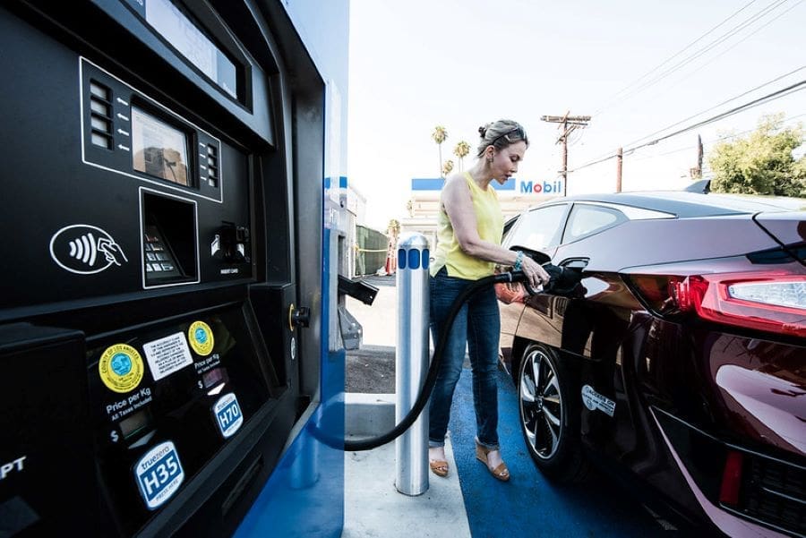 Image: Person fuels car at a hydrogen fueling station (s. climate change solutions)