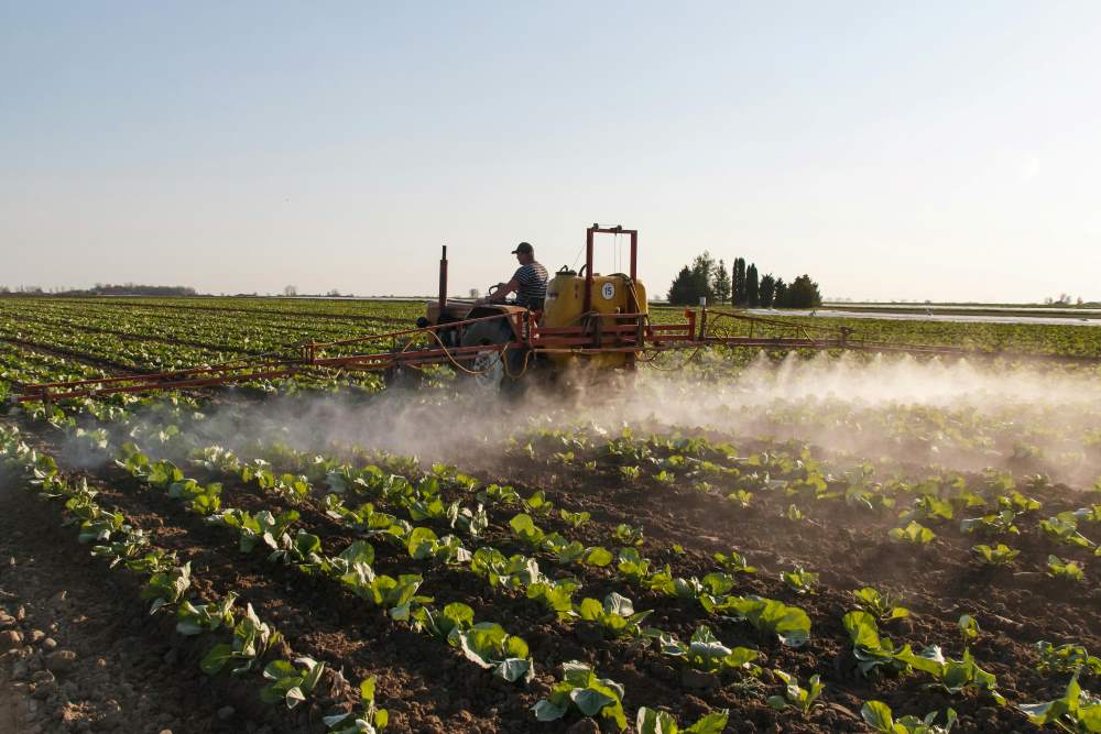 Image: Traktor spraying pesticides (s. water wells, pollution, health)