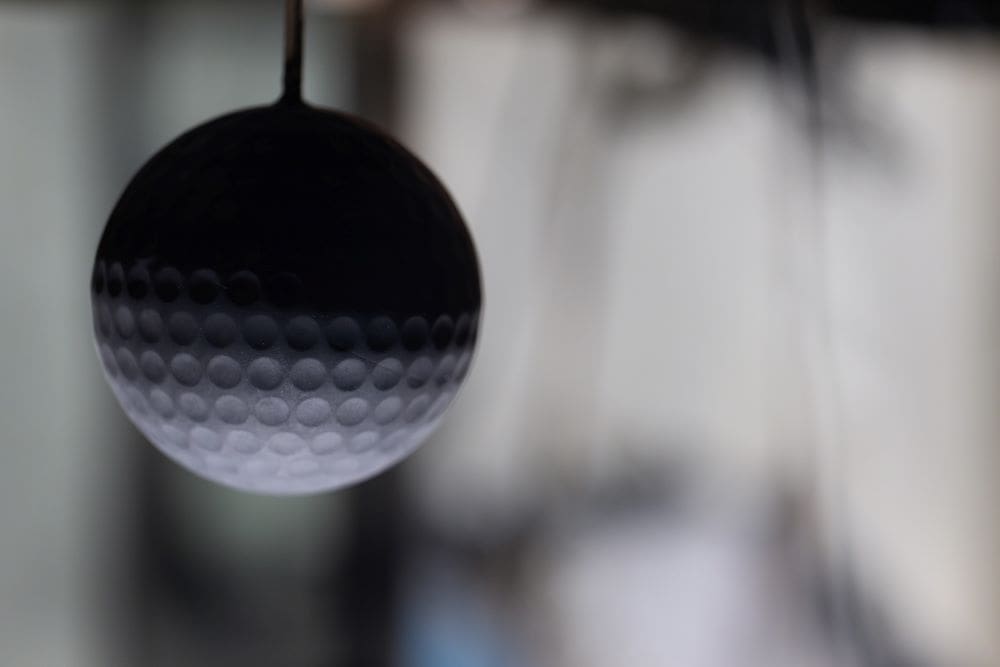 Image: A spherical prototype with adjustable surface dimples is suspended in a wind tunnel, ready to test drag.