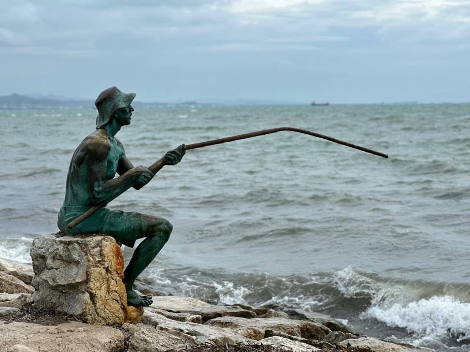 Image: Bronze Fisherman Statue by the Sea Coast, Albania (s. climate change, erosion, coastline, tourism)