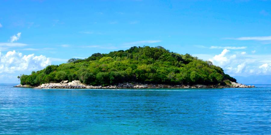 Image: Island covered with green trees under a clear sky (s. climate change, erosion, coastline, tourism)