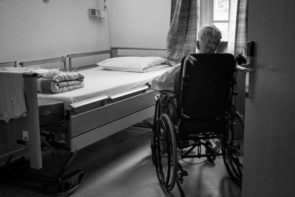 Image: a person in a wheelchair in a hospital room