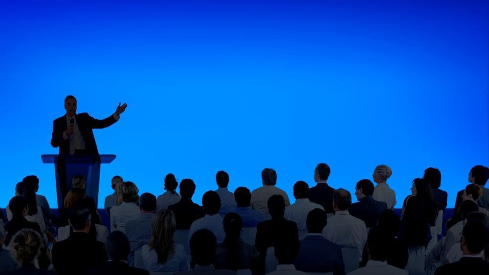 Image: Corporate businessman giving a presentation to a large audience (s. climate conference)