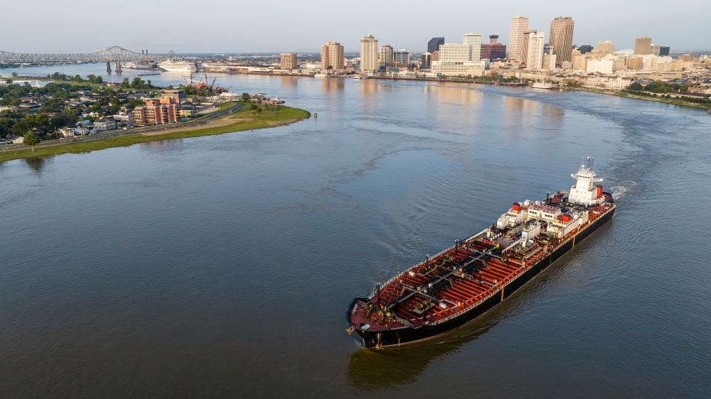 Image: a large boat traveling down a river next to a city (s. science, climate, Muser)
