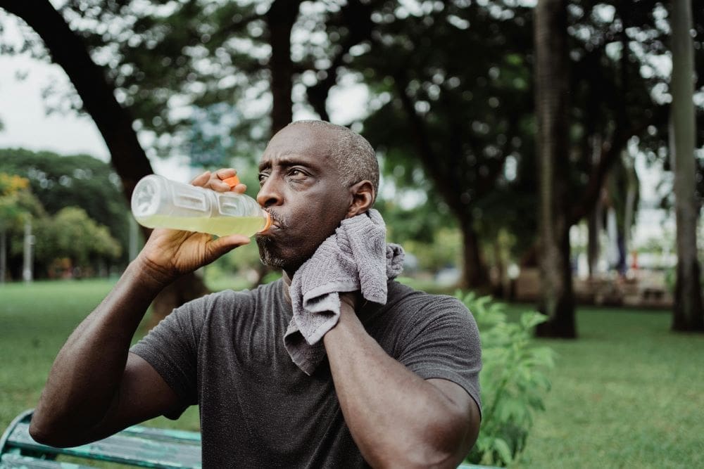Image: Man drinking from a plastic bottle, sweating (s. Asia aerosol emissions, global warming)