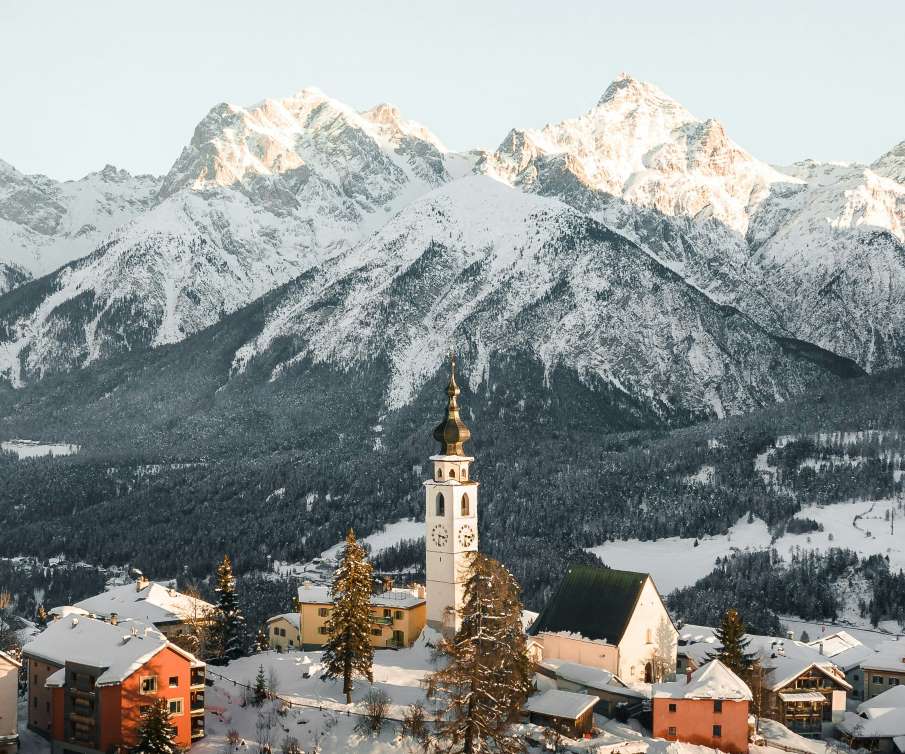 Image: white and brown concrete building near snow covered mountain during daytime