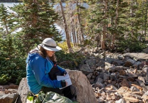 Climate Science Digest: November 19, 2025 Image: Chris Ray makes notes during a survey of pikas