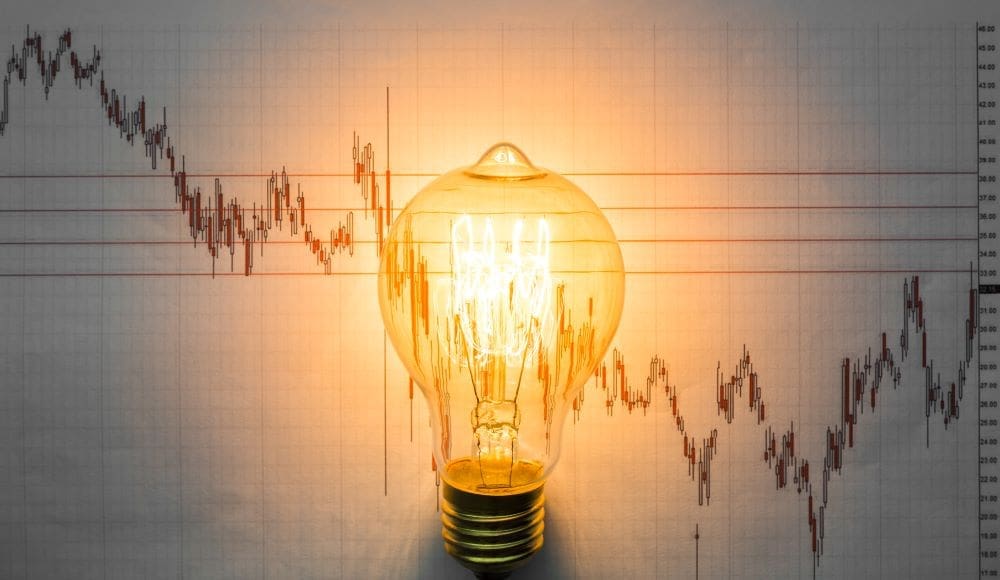 Image: Lit light bulb with graph background