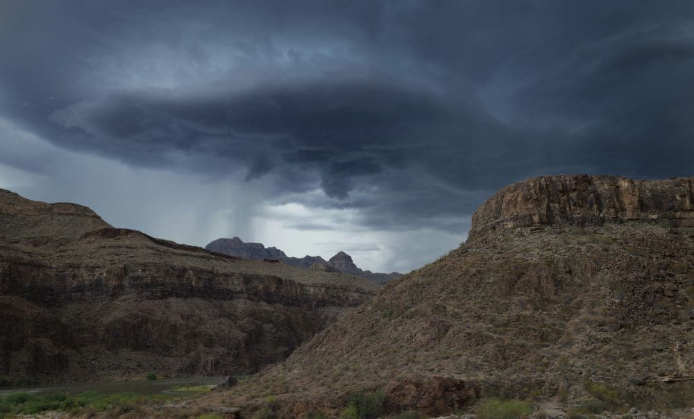 Image: clouds gather over a rugged desert landscape