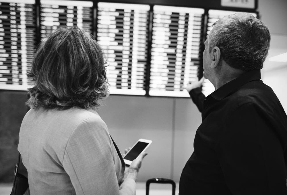 Image: a couple checking flight time schedule (s. weather, winds)