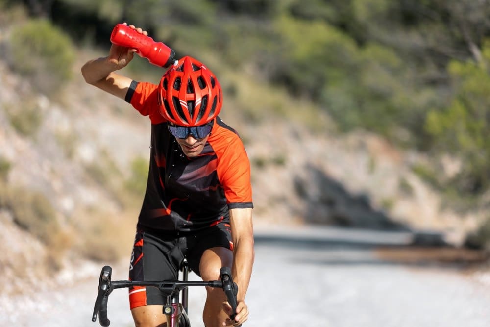 Image: Man cycling outdoors with his bike and helmet