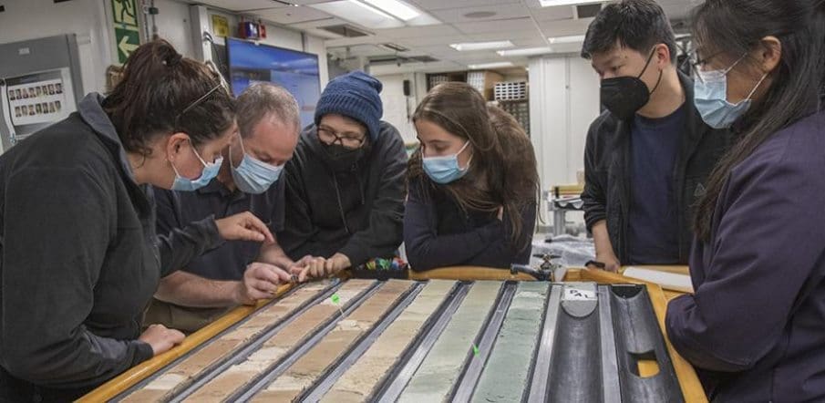 Image: scientists examining a sediment core (s. human evolution, glacial climate shift)