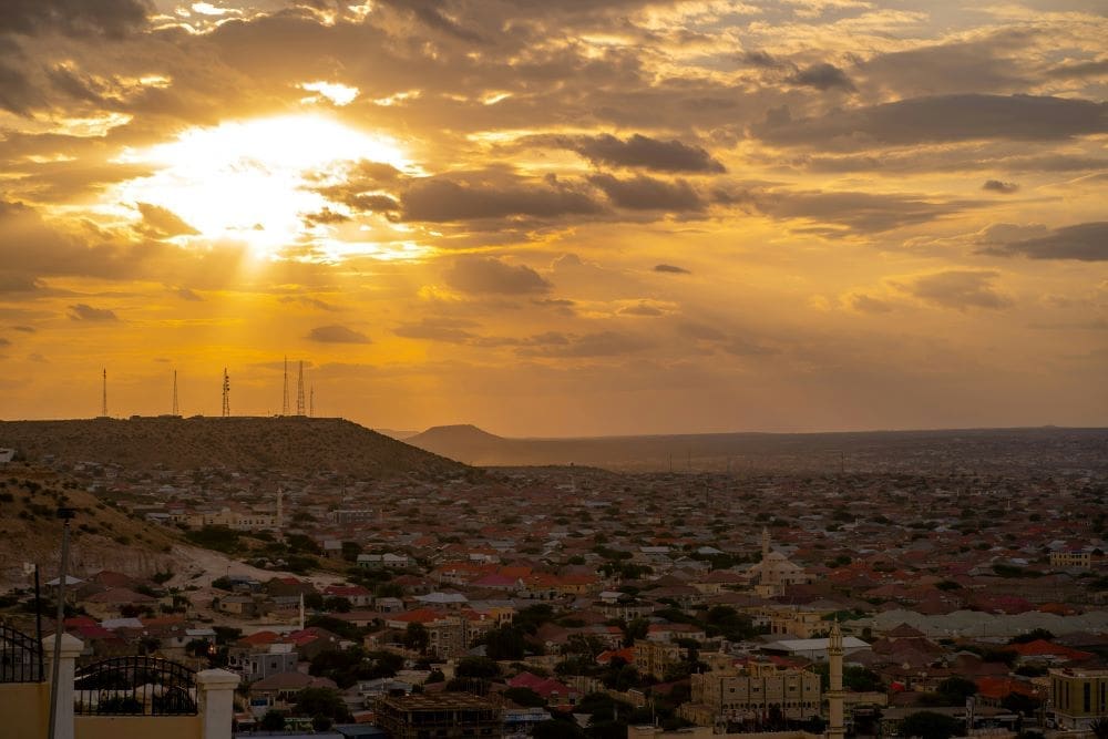 Image: sun is setting over a city and hills (Hargeisa, Somalia)