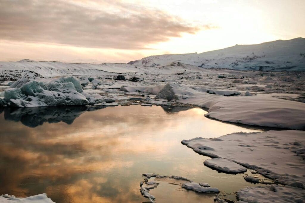 Arctic melt ponds identified as source of cloud-forming particles Image: Scenic View of a Snow Covered Landscape (s. pond, Arctic, clouds)