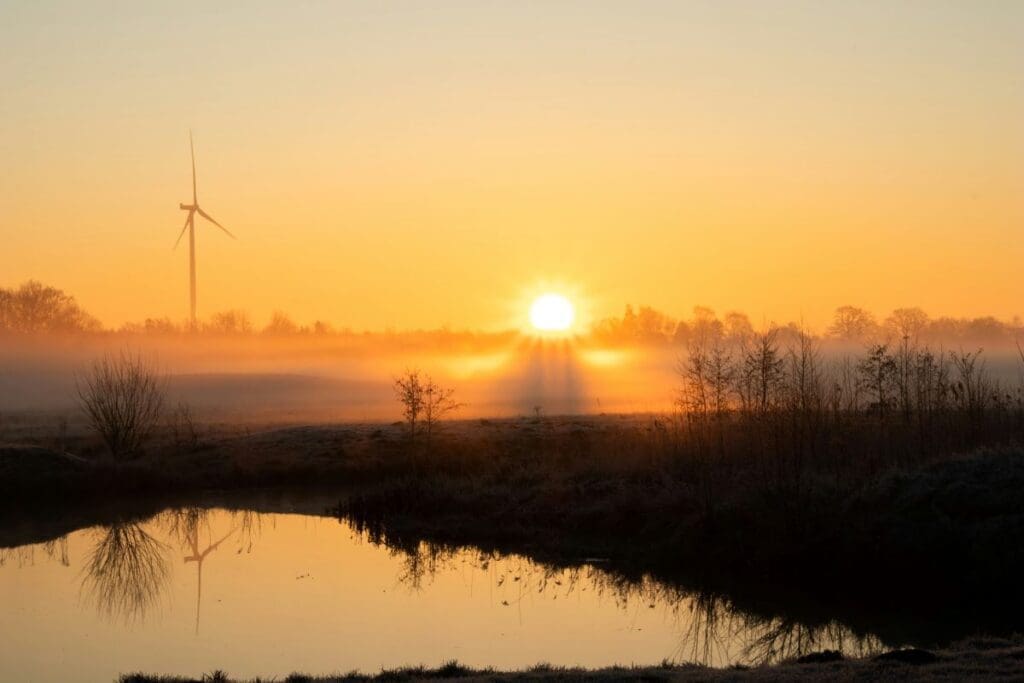 Image: solitary wind turbine stands tall on the horizon, symbolizing the blend of nature and sustainable energy