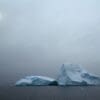 Image: icebergs float in a foggy ocean under sun (s. dimmed sunlight)