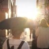 Image: woman in white shirt holding umbrella in a sunny day