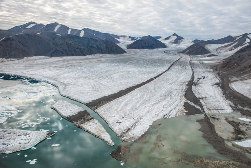 Arctic iceberg traffic has surged since 2000, reshaping deep-sea biodiversity Image: Aerial view of a calving glacier with rock inclusions in northern Greenland in summer 2016