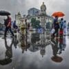 Image: a group of people walking down a street holding umbrellas