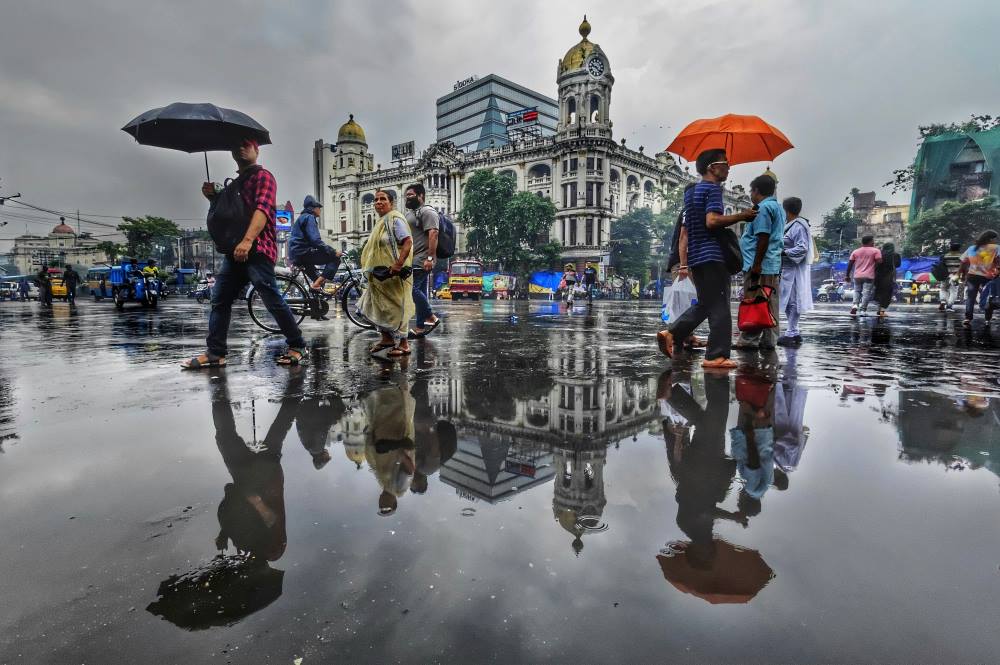 Image: a group of people walking down a street holding umbrellas
