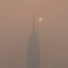 Hazardous Canadian wildfire smoke choking millions in US Image: a foggy skyline with a tall building in the distance